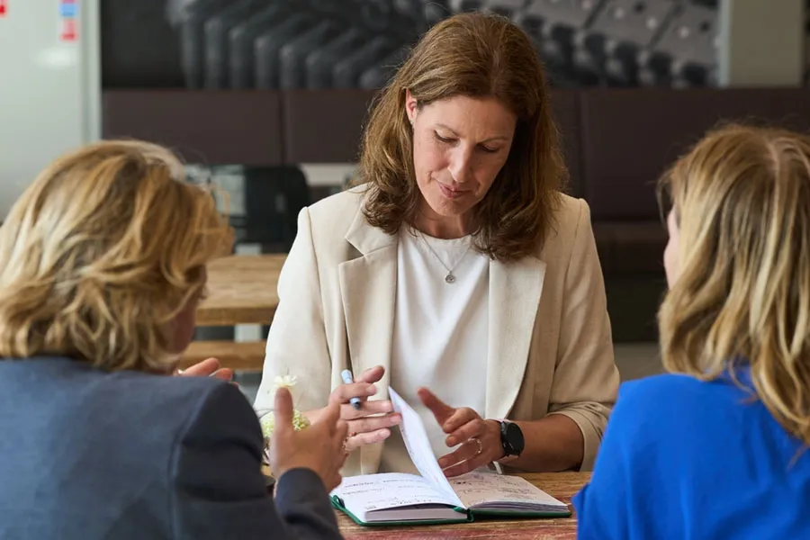 Adviseur van HB in gesprek met twee klanten aan tafel